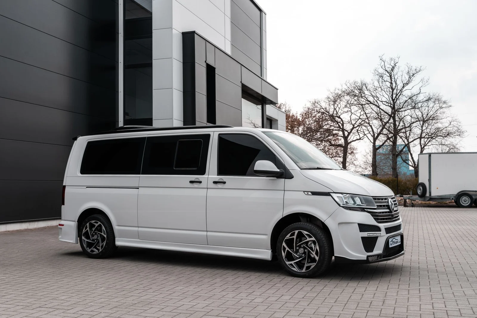 Weißer VW T6.1 in Seitenansicht mit verglaster Seitenwand und eingesetztem Schiebefenster