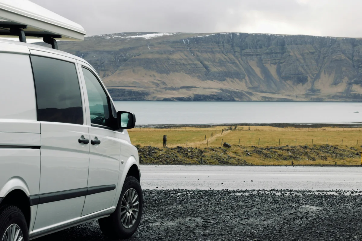 Camper Van an einem ruhigen Stellplatz vor einem See