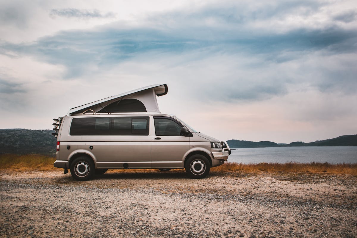 Camper mit geöffnetem Aufstelldach am See – mehr Stehhöhe und zusätzlicher Schlafplatz beim VW T6/T6.1